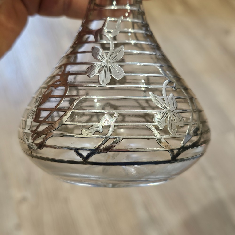 An early 20th-century glass decanter featuring an intricate sterling silver floral overlay and matching stopper. View VIII