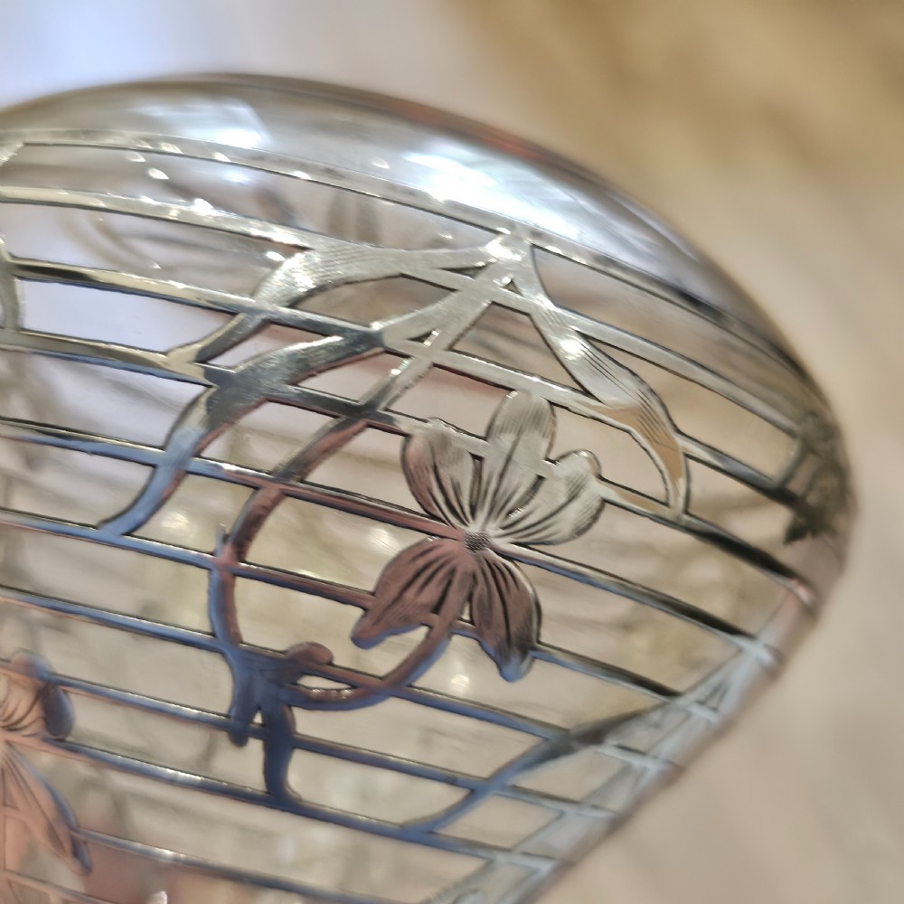 An early 20th-century glass decanter featuring an intricate sterling silver floral overlay and matching stopper. View IX