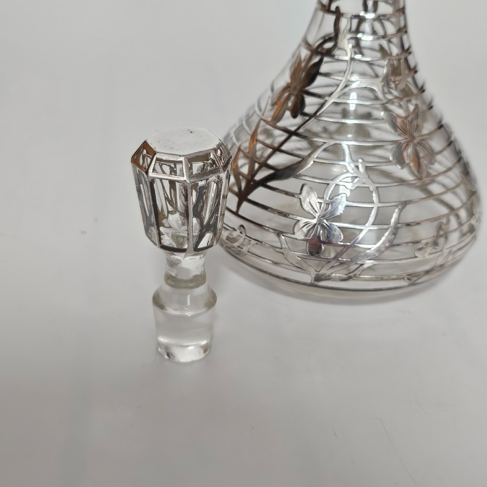 An early 20th-century glass decanter featuring an intricate sterling silver floral overlay and matching stopper. View XIV
