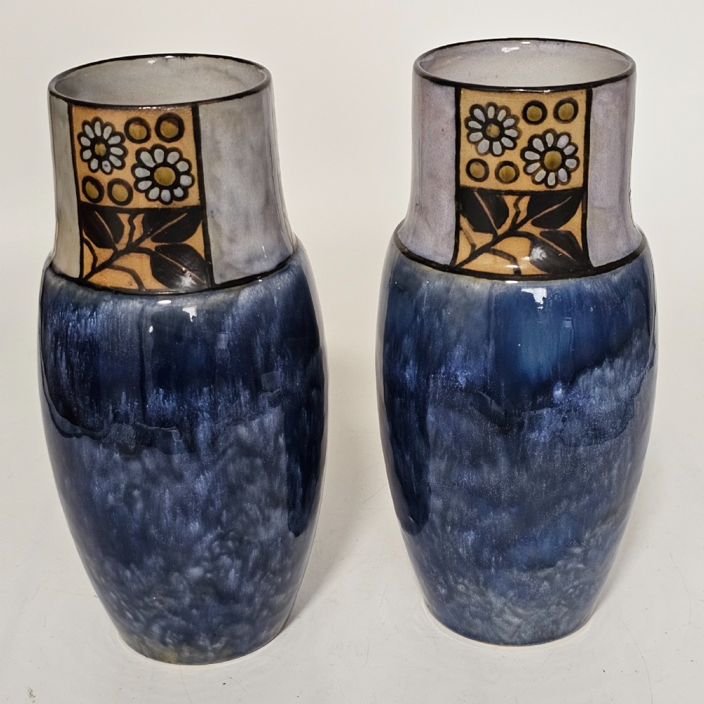 A pair of Royal Doulton stoneware vases featuring mottled blue glaze bodies and upper decorative bands with hand-painted floral motifs. View VII