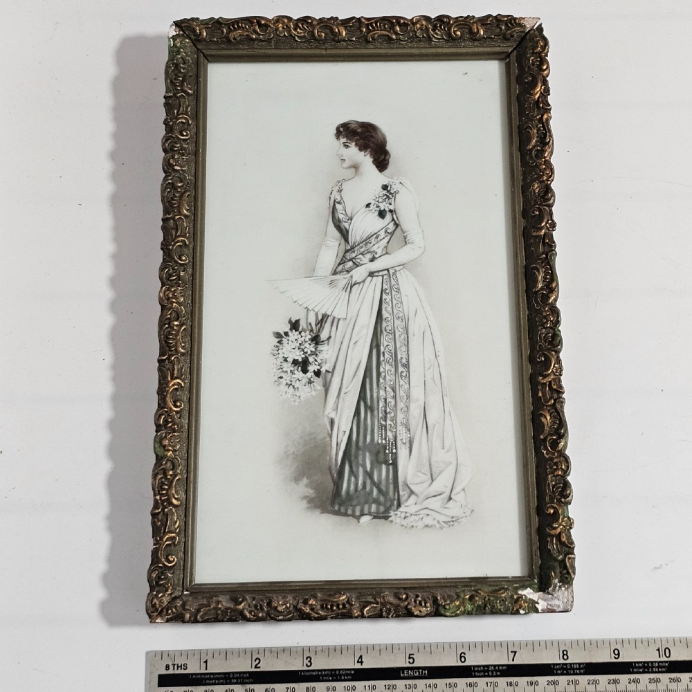 A rectangular framed porcelain plaque featuring a monochrome depiction of an Edwardian lady holding a fan within an ornate gilt frame. View VI