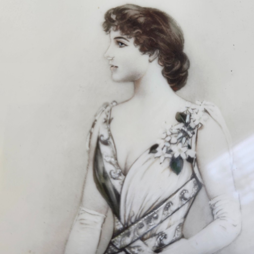 A rectangular framed porcelain plaque featuring a monochrome depiction of an Edwardian lady holding a fan within an ornate gilt frame. View VII