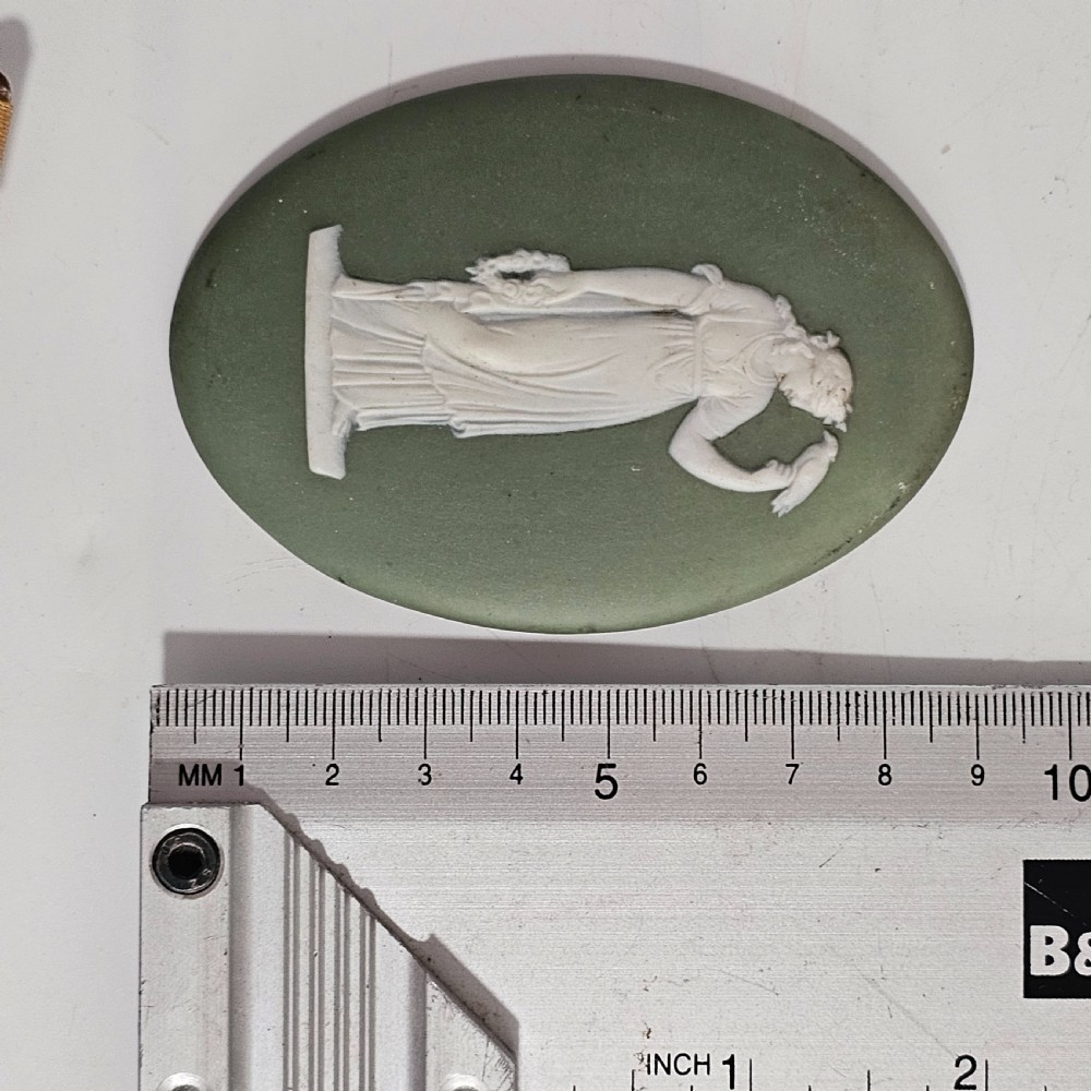 A pair of oval sage green stoneware plaques decorated with raised white relief figures in classical drapery. View VI