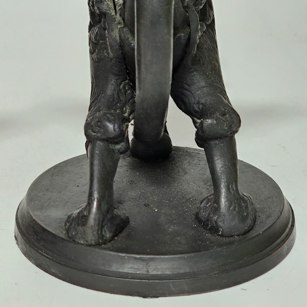 A pair of heavy dark bronze chambersticks featuring mythical griffin figures holding candle nozzles. View XVIII