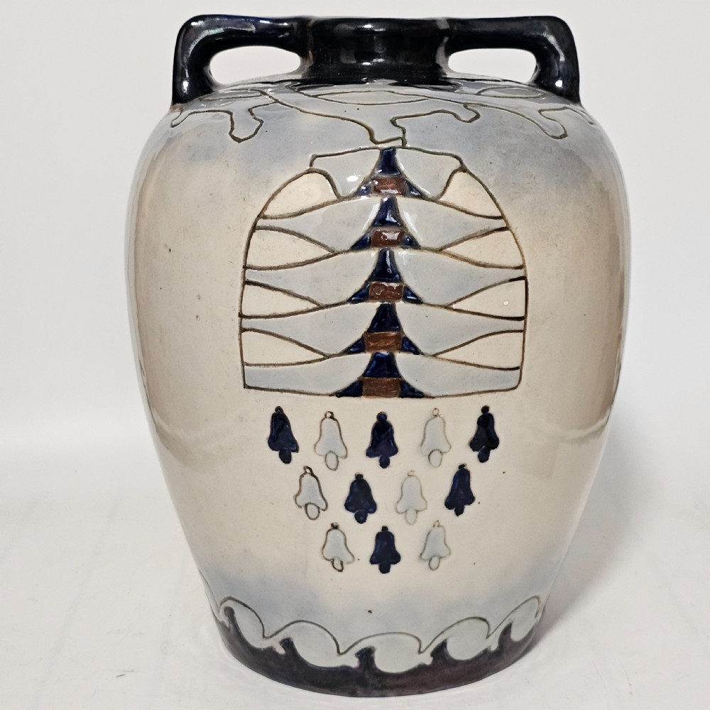 A twin-handled cream ceramic Amphora vase decorated with a stylized bird motif in blue and dark glazes. View II