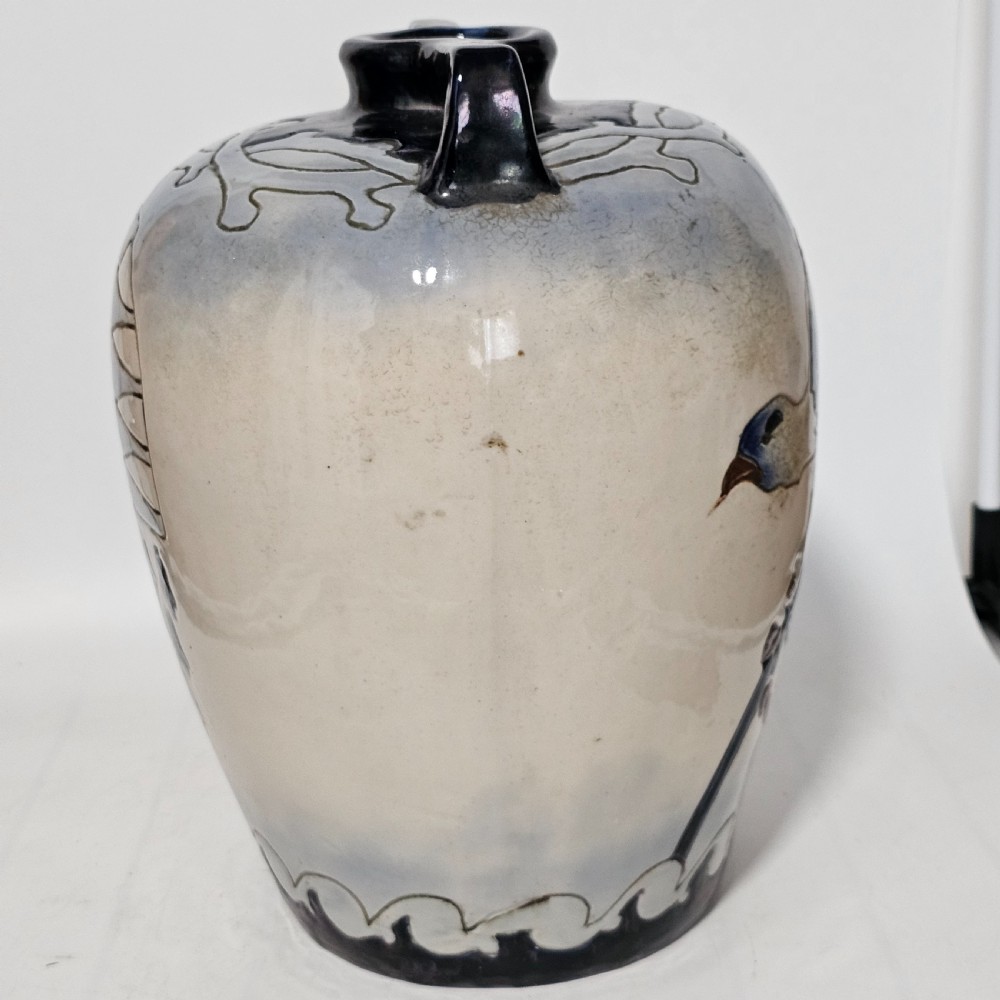 A twin-handled cream ceramic Amphora vase decorated with a stylized bird motif in blue and dark glazes. View VI