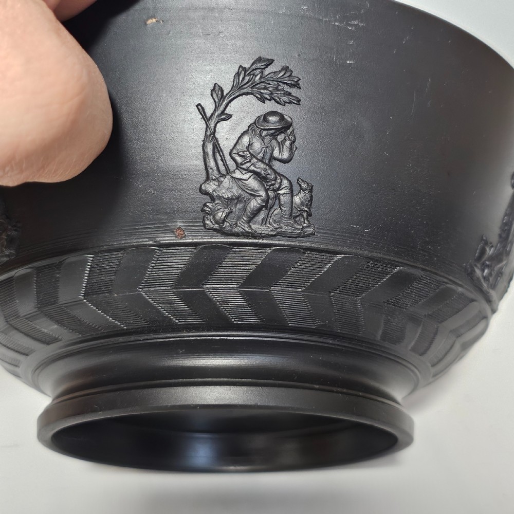 An antique matte black basalt stoneware bowl featuring classical figures in relief around the body and an engine-turned border above the circular foot. View VI