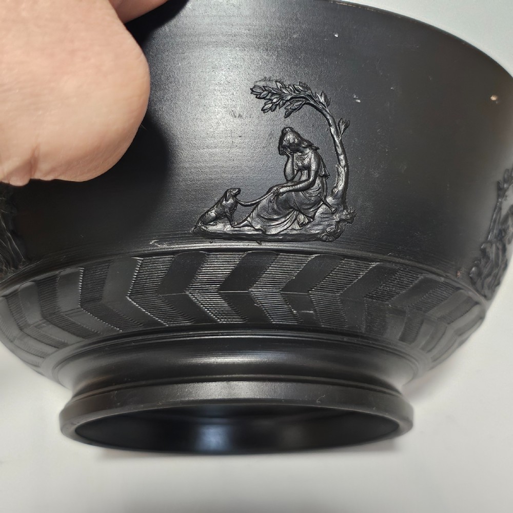 An antique matte black basalt stoneware bowl featuring classical figures in relief around the body and an engine-turned border above the circular foot. View VII