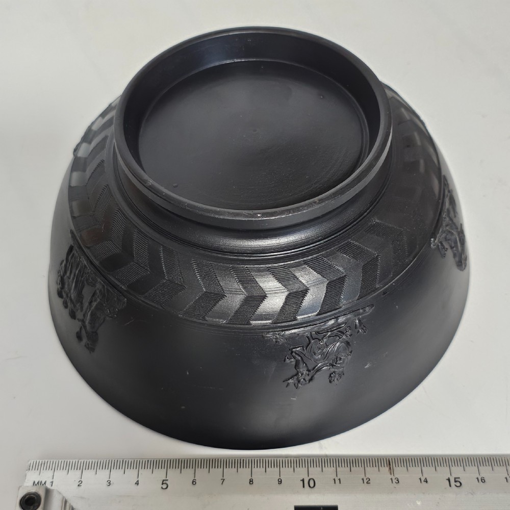 An antique matte black basalt stoneware bowl featuring classical figures in relief around the body and an engine-turned border above the circular foot. View VIII