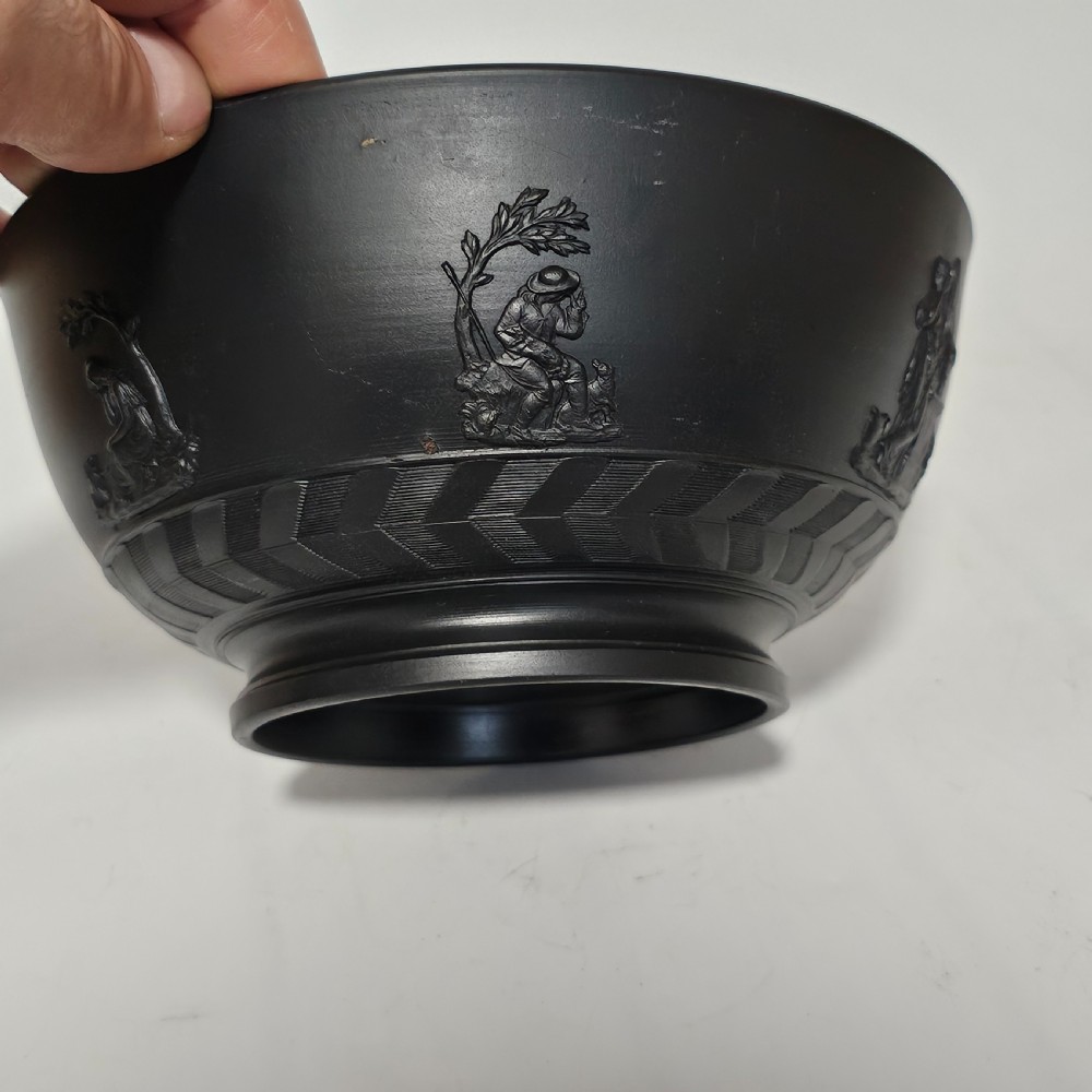 An antique matte black basalt stoneware bowl featuring classical figures in relief around the body and an engine-turned border above the circular foot. View XI