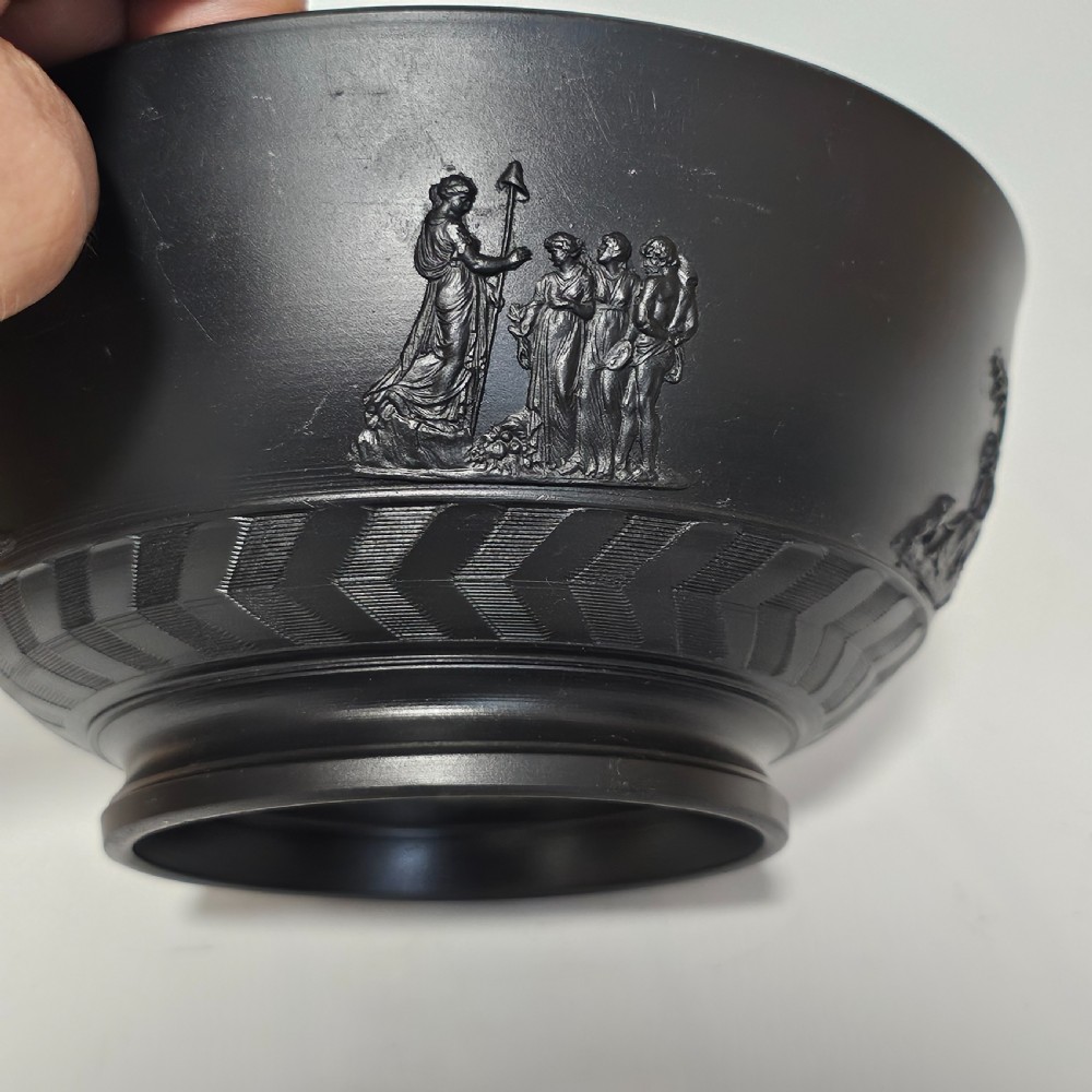 An antique matte black basalt stoneware bowl featuring classical figures in relief around the body and an engine-turned border above the circular foot. View XII