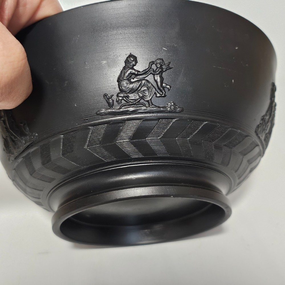 An antique matte black basalt stoneware bowl featuring classical figures in relief around the body and an engine-turned border above the circular foot. View XIII
