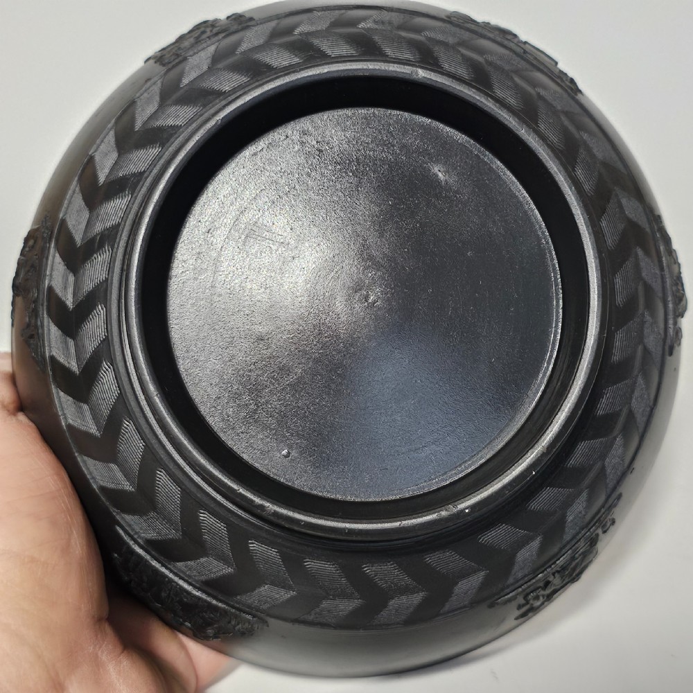An antique matte black basalt stoneware bowl featuring classical figures in relief around the body and an engine-turned border above the circular foot. View XV