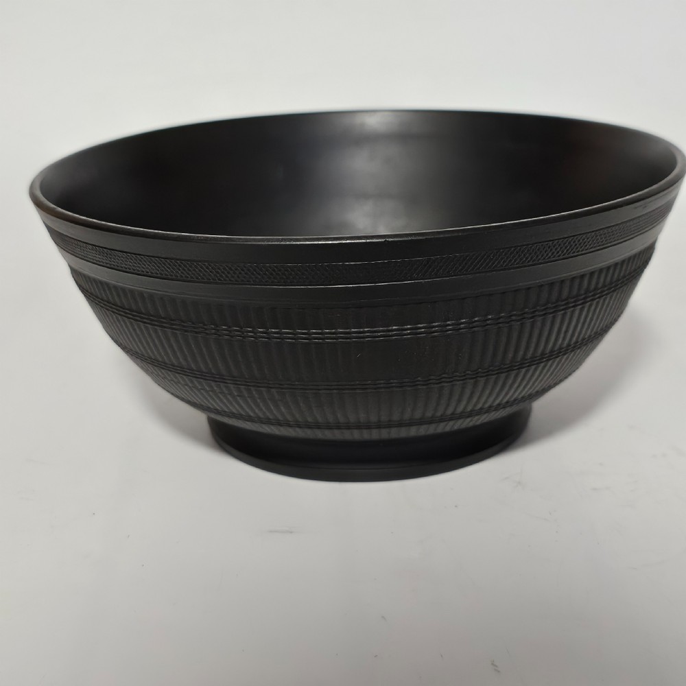 An 18th-century matte black basalt stoneware bowl featuring intricate engine-turned reeded and diced patterns around the exterior. View II