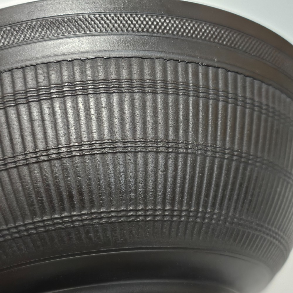 An 18th-century matte black basalt stoneware bowl featuring intricate engine-turned reeded and diced patterns around the exterior. View III