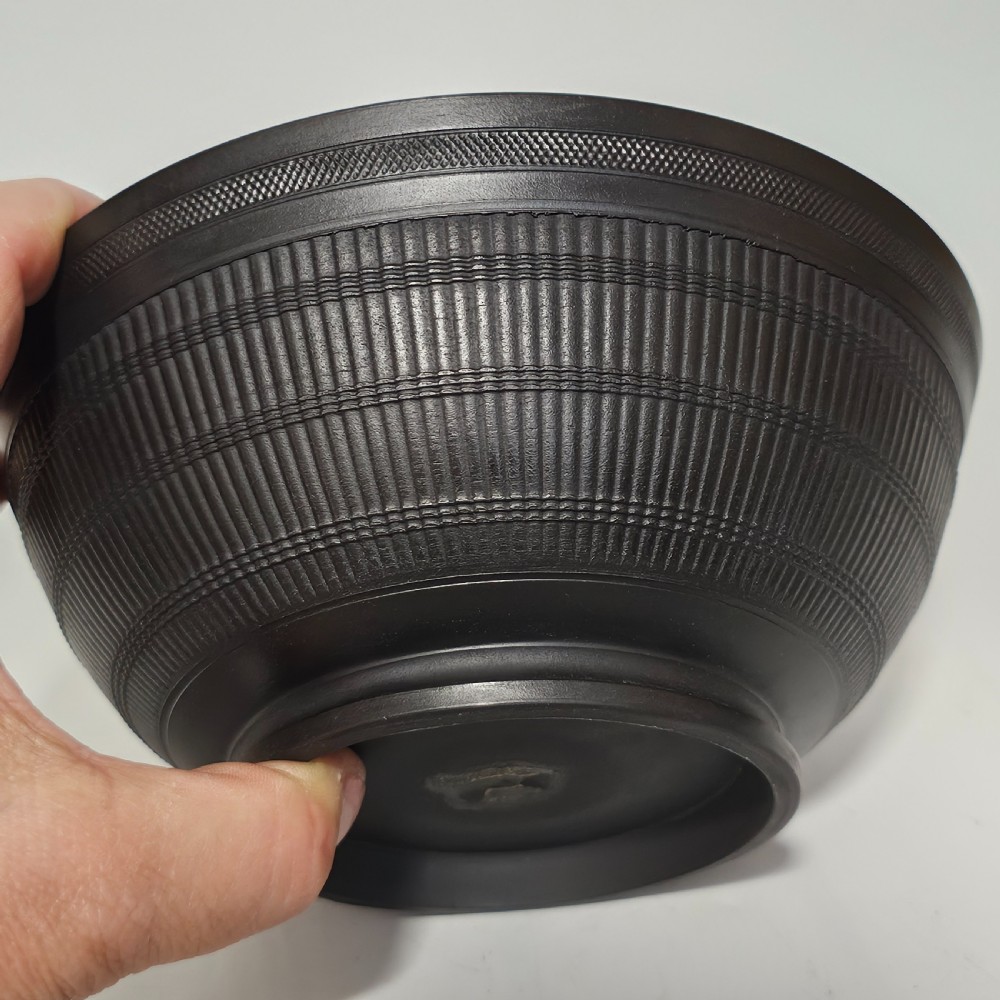 An 18th-century matte black basalt stoneware bowl featuring intricate engine-turned reeded and diced patterns around the exterior. View VII