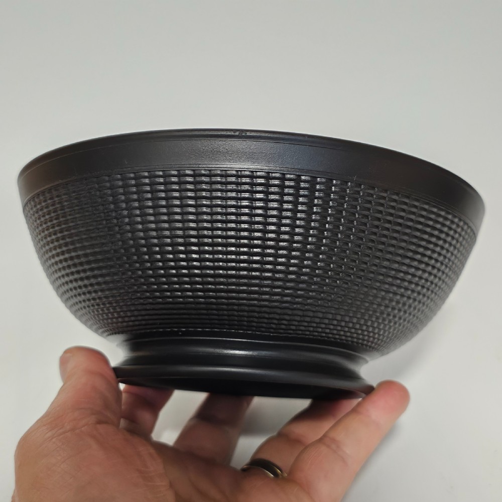 A large matte black basalt stoneware bowl with a textured pattern around the lower body and a circular foot. View III