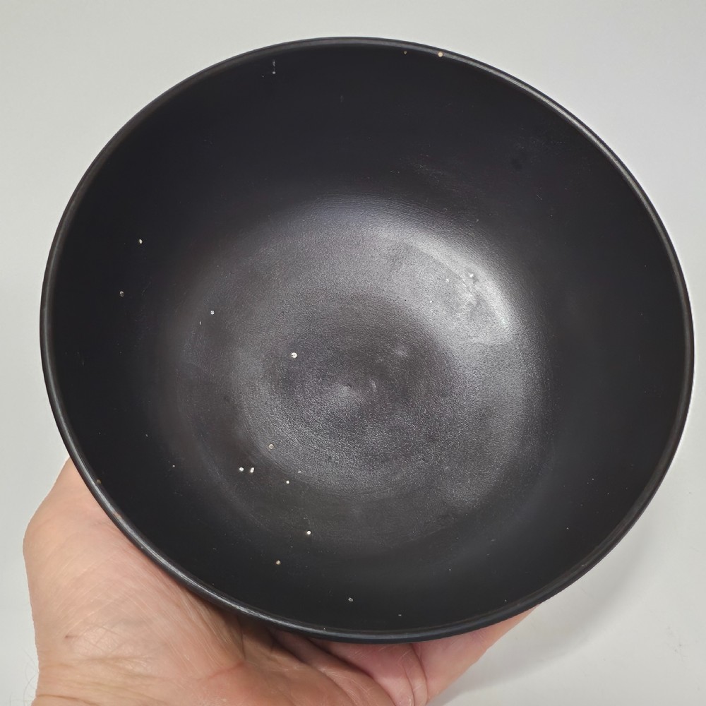 A large matte black basalt stoneware bowl with a textured pattern around the lower body and a circular foot. View VIII