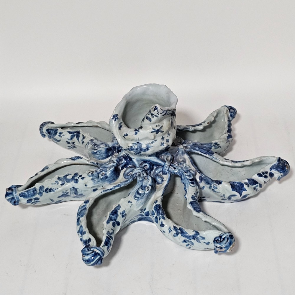 A hand-painted blue and white ceramic starfish dish featuring intricate floral patterns and an elevated central opening.
