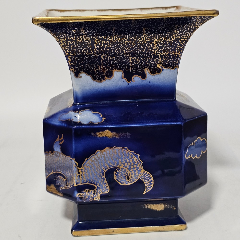 A flared hexagonal cobalt blue porcelain vase decorated with a gilded dragon motif and gold rim. View V