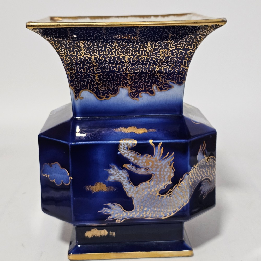 A flared hexagonal cobalt blue porcelain vase decorated with a gilded dragon motif and gold rim. View III