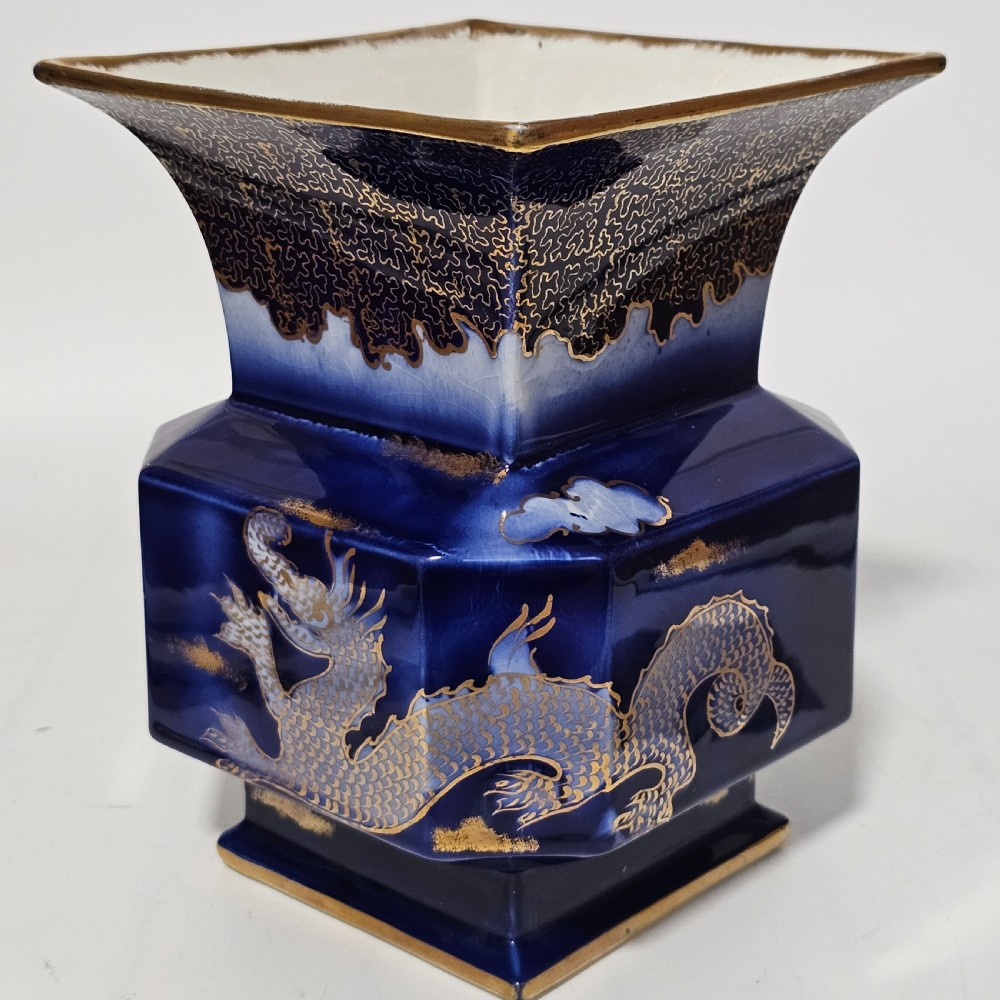 A flared hexagonal cobalt blue porcelain vase decorated with a gilded dragon motif and gold rim. View IX