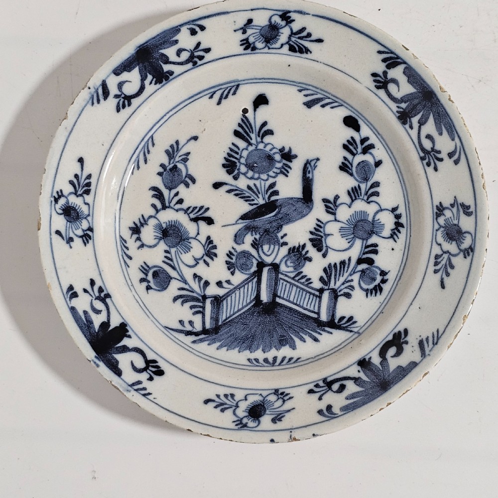 A pair of round antique Delft ceramic plates featuring hand-painted blue and white bird and floral motifs on a white tin-glazed background. View IX