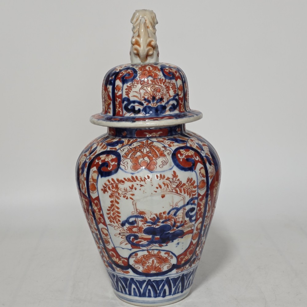 A 19th-century Japanese Imari porcelain covered jar decorated with cobalt blue and rust red floral panel motifs, topped with a sculpted foo dog finial lid. View III