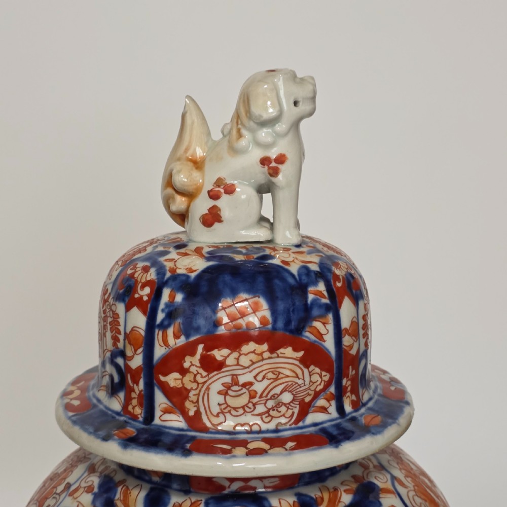 A 19th-century Japanese Imari porcelain covered jar decorated with cobalt blue and rust red floral panel motifs, topped with a sculpted foo dog finial lid. View VI