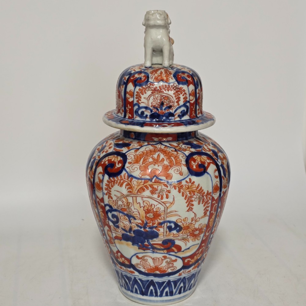 A 19th-century Japanese Imari porcelain covered jar decorated with cobalt blue and rust red floral panel motifs, topped with a sculpted foo dog finial lid. View VII