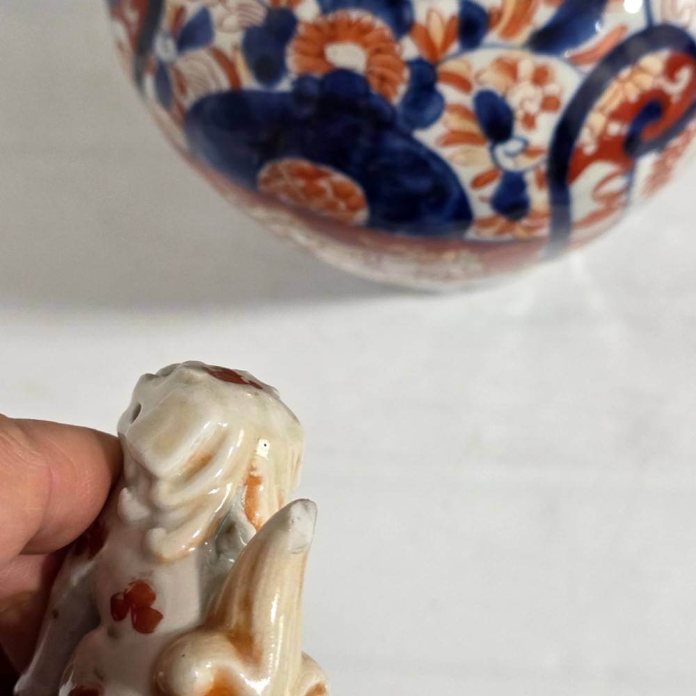 A 19th-century Japanese Imari porcelain covered jar decorated with cobalt blue and rust red floral panel motifs, topped with a sculpted foo dog finial lid. View IX