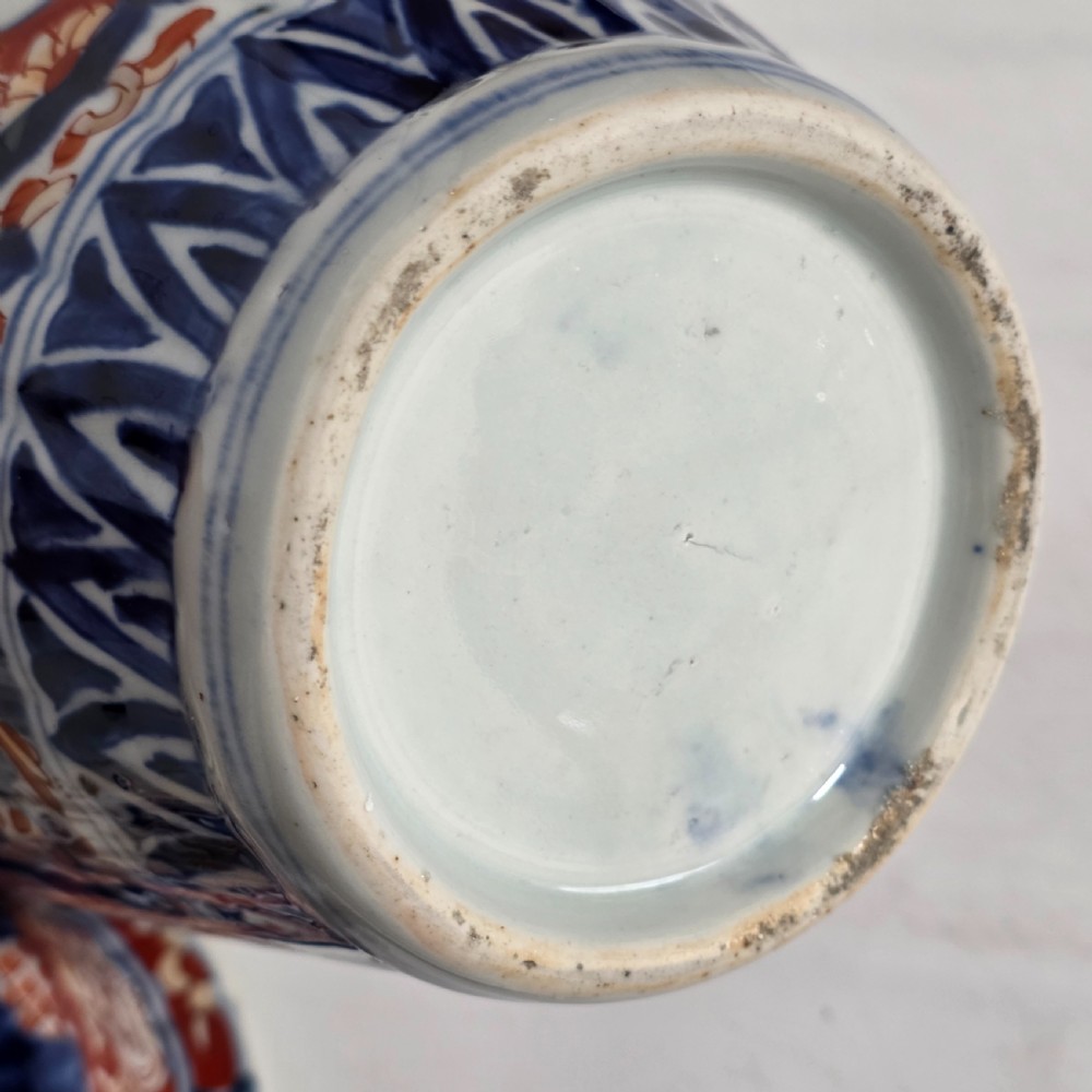 A 19th-century Japanese Imari porcelain covered jar decorated with cobalt blue and rust red floral panel motifs, topped with a sculpted foo dog finial lid. View XI