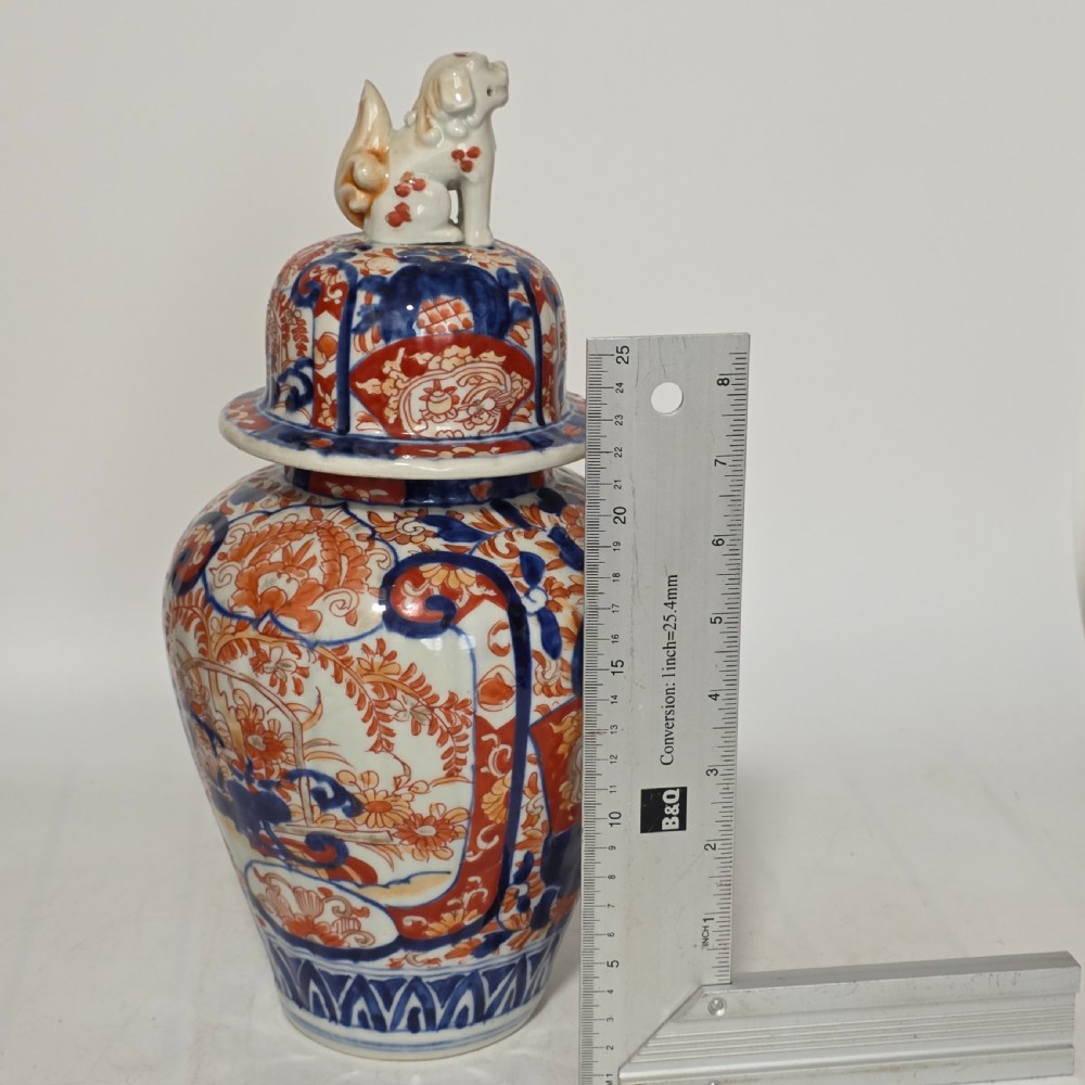 A 19th-century Japanese Imari porcelain covered jar decorated with cobalt blue and rust red floral panel motifs, topped with a sculpted foo dog finial lid. View XIII