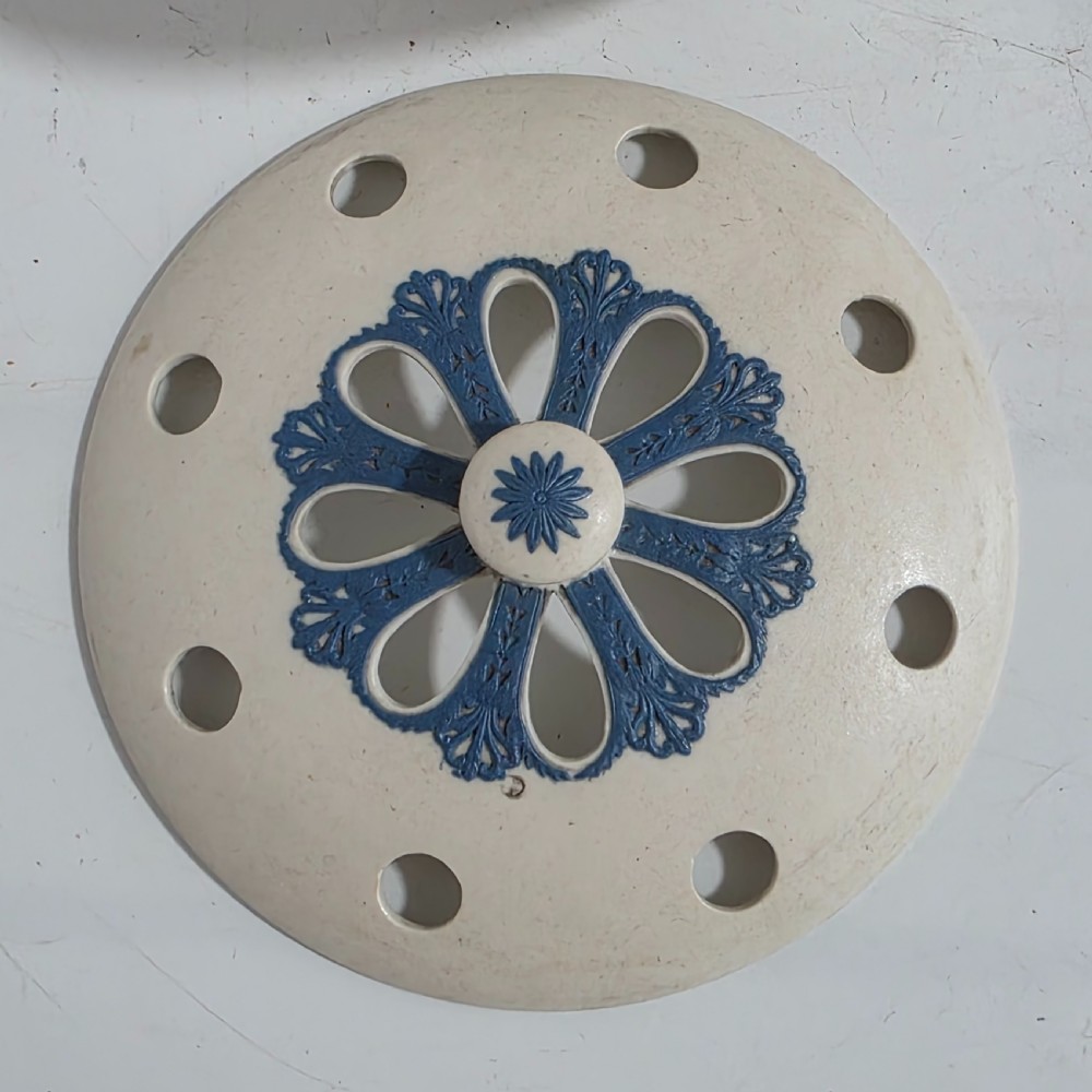 An off-white Georgian stoneware pot pourri basket featuring an overhead handle, pierced cover, and cobalt blue applied grapevine sprig decoration. View XVI