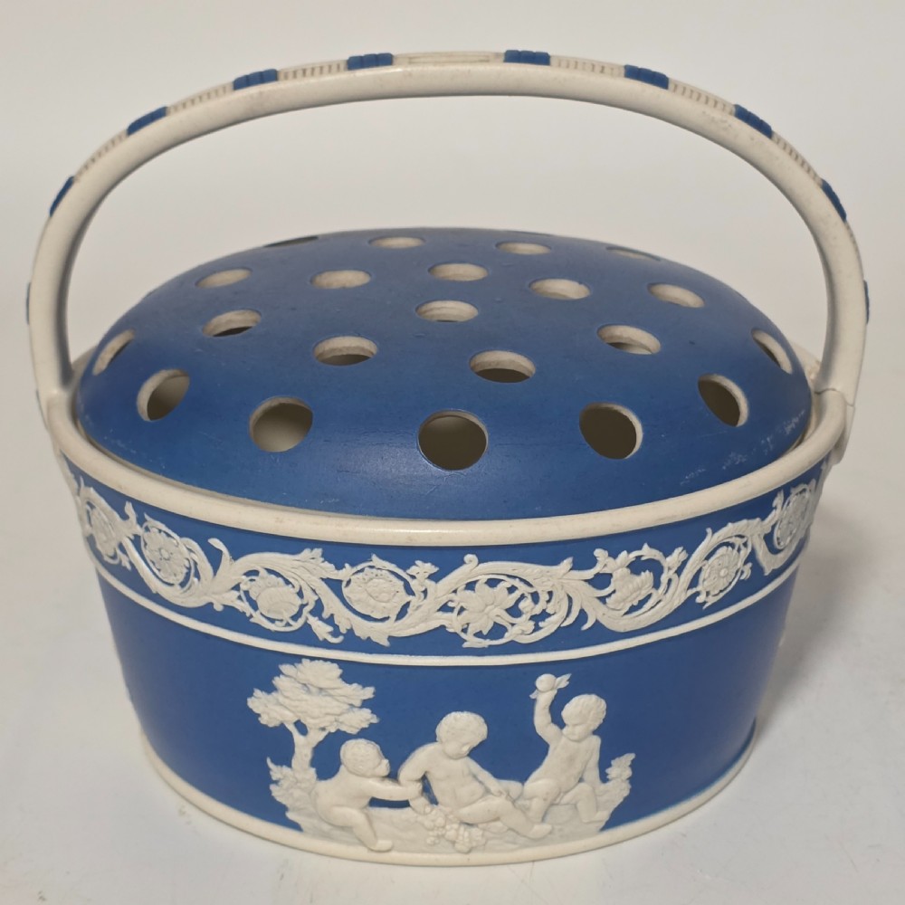A pair of blue and white Georgian ceramic pot pourri baskets with pierced lids, white classical cherub reliefs, and overhead handles. View XII