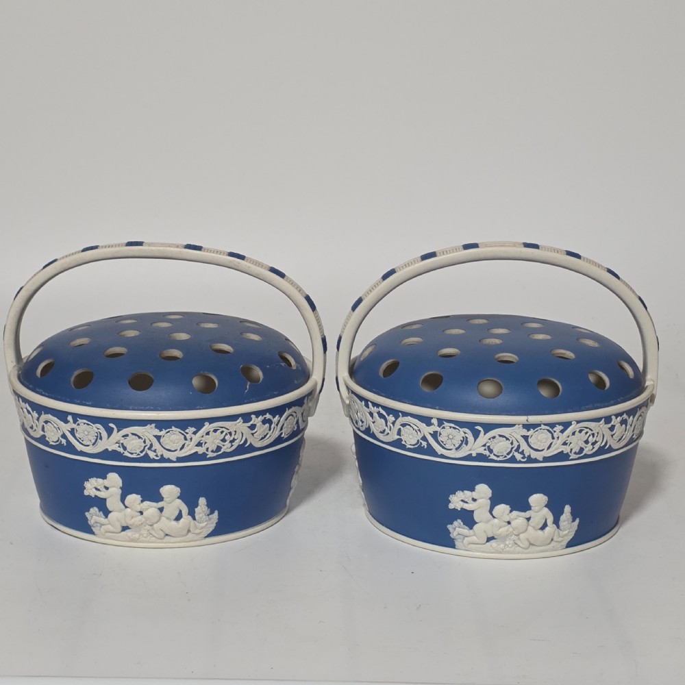 A pair of blue and white Georgian ceramic pot pourri baskets with pierced lids, white classical cherub reliefs, and overhead handles. View XIII