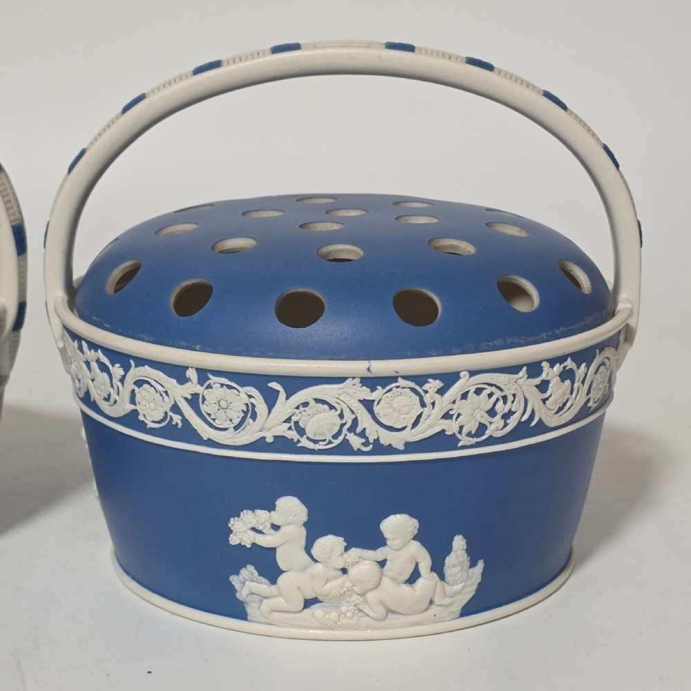 A pair of blue and white Georgian ceramic pot pourri baskets with pierced lids, white classical cherub reliefs, and overhead handles. View XIV