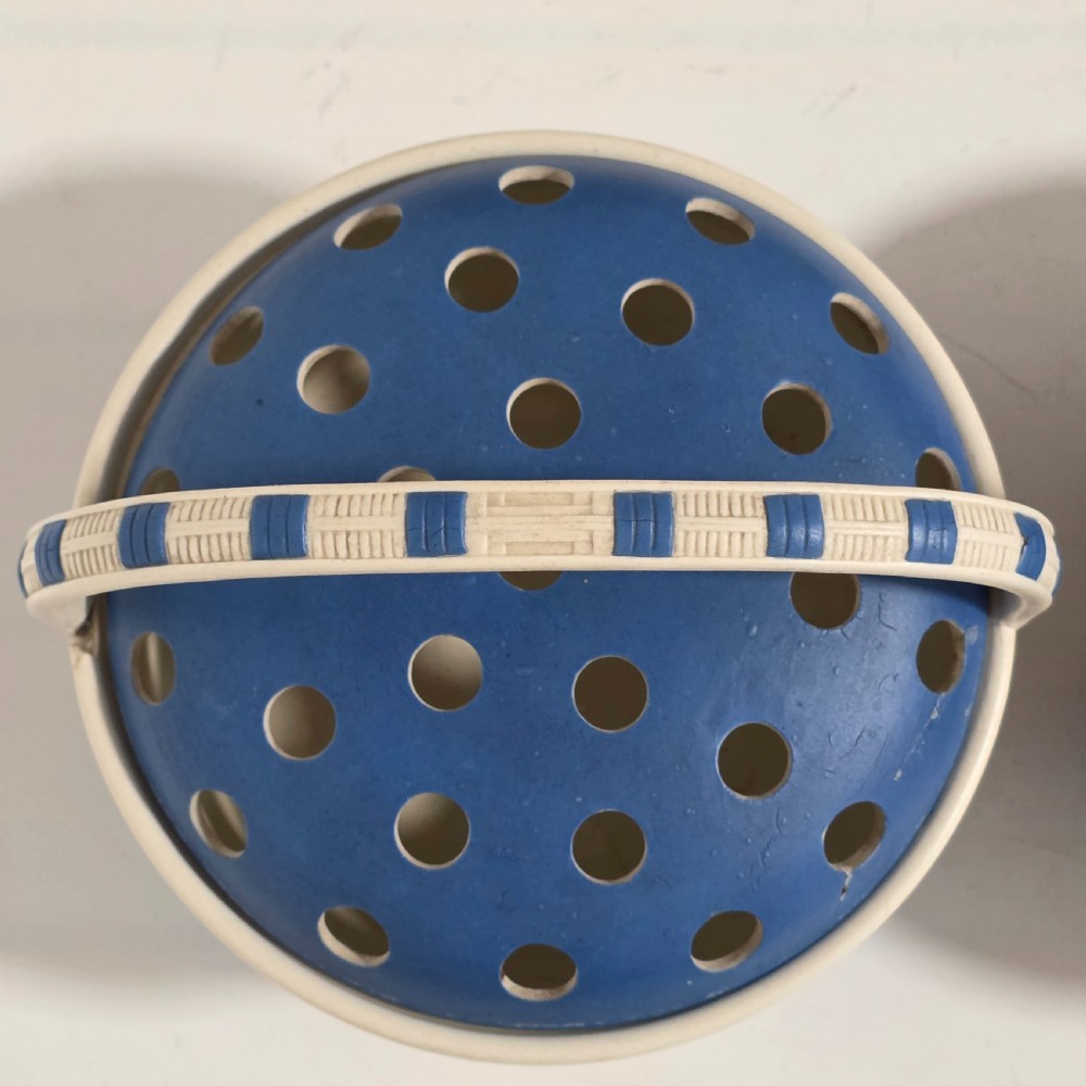 A pair of blue and white Georgian ceramic pot pourri baskets with pierced lids, white classical cherub reliefs, and overhead handles. View XVI