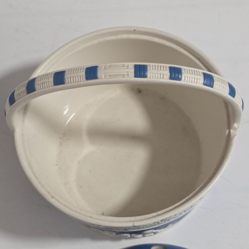 A pair of blue and white Georgian ceramic pot pourri baskets with pierced lids, white classical cherub reliefs, and overhead handles. View XVIII