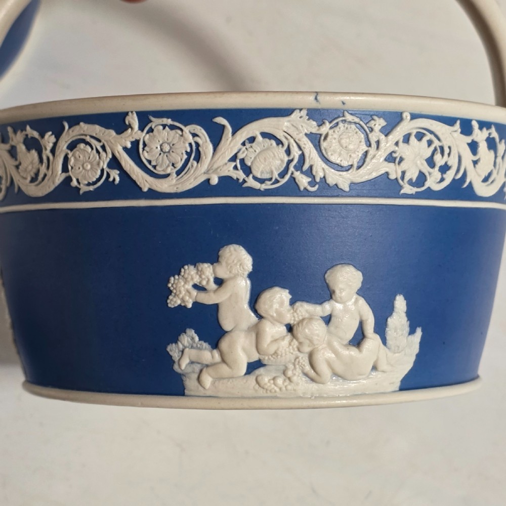 A pair of blue and white Georgian ceramic pot pourri baskets with pierced lids, white classical cherub reliefs, and overhead handles. View XIX