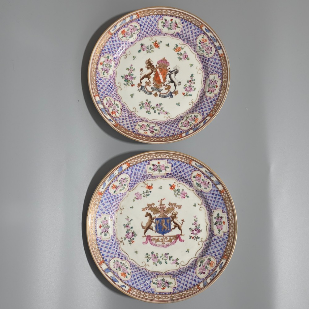 A pair of nineteenth-century Samson porcelain cabinet plates featuring hand-painted coat of arms crests surrounded by floral sprays and purple lattice borders.