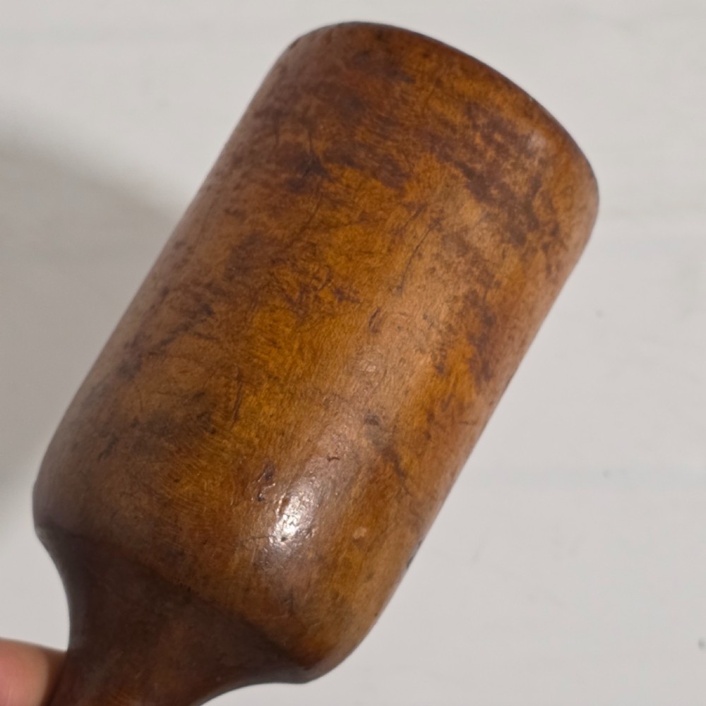 A 19th-century hand-turned sycamore wood potato masher featuring a domed cap top, slender baluster handle, and smooth cylindrical base. View V