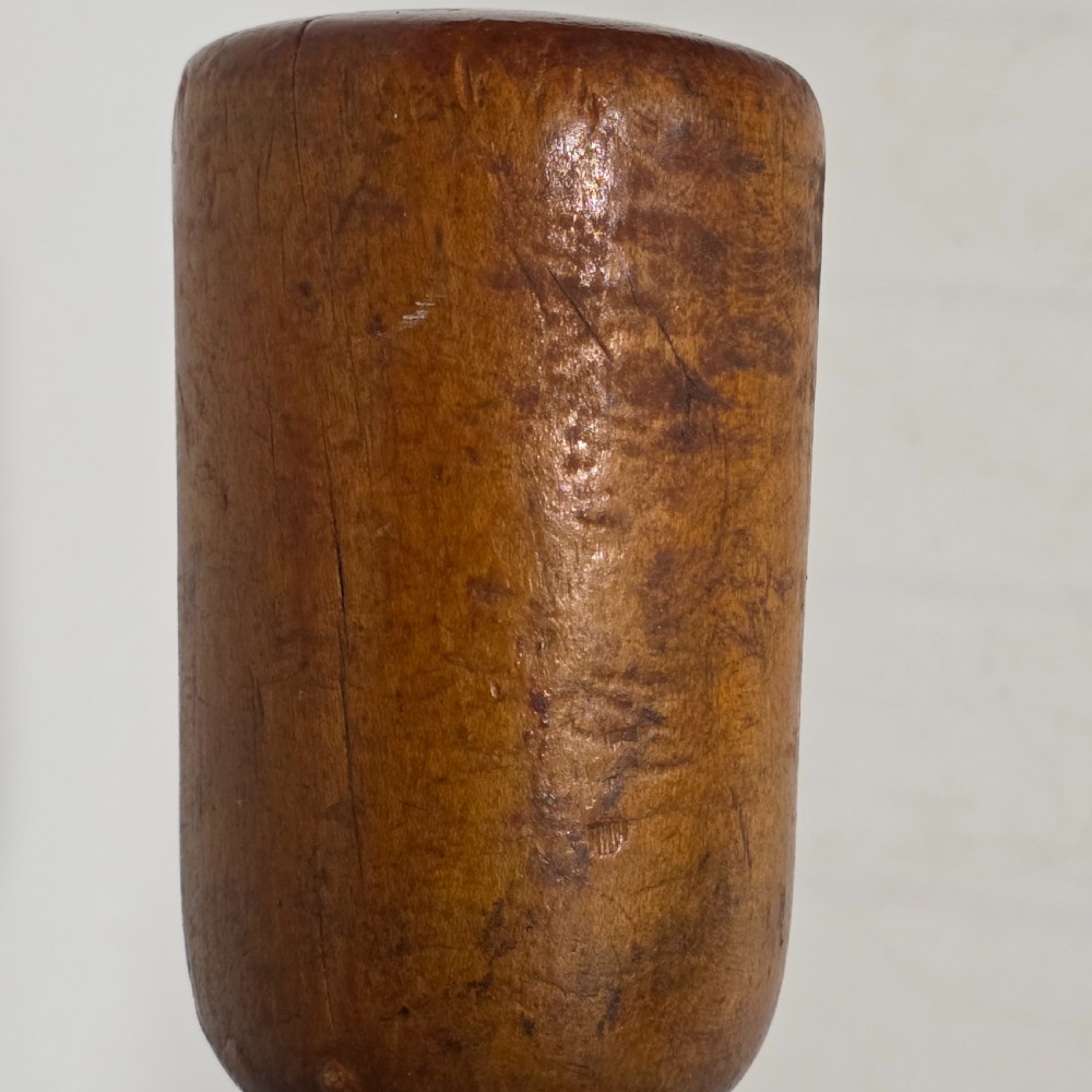 A 19th-century hand-turned sycamore wood potato masher featuring a domed cap top, slender baluster handle, and smooth cylindrical base. View XIV