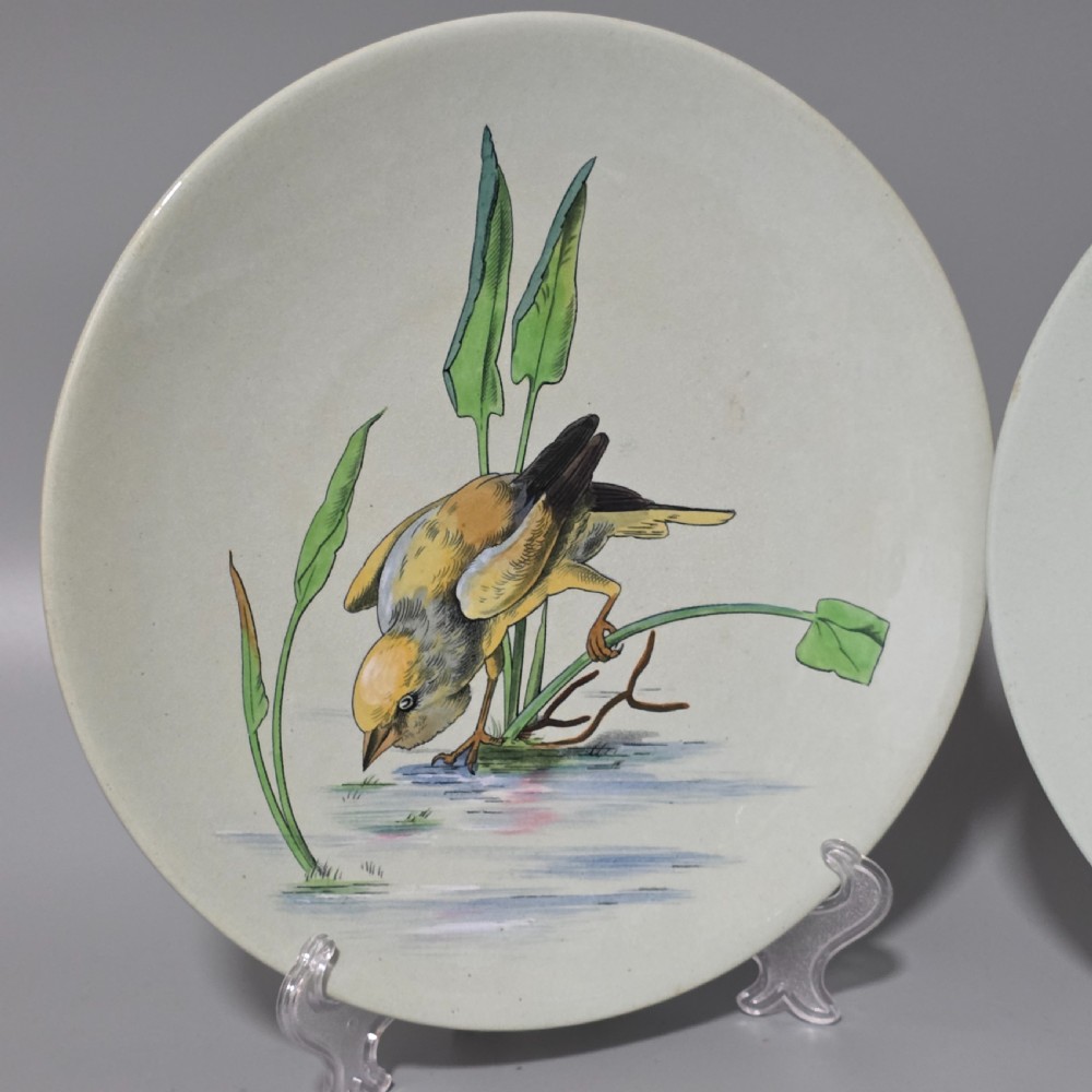 A pair of circular pale green ceramic display plates hand painted with detailed birds near water lilies and reeds. View III