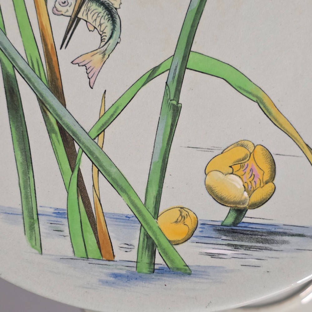 A pair of circular pale green ceramic display plates hand painted with detailed birds near water lilies and reeds. View IX