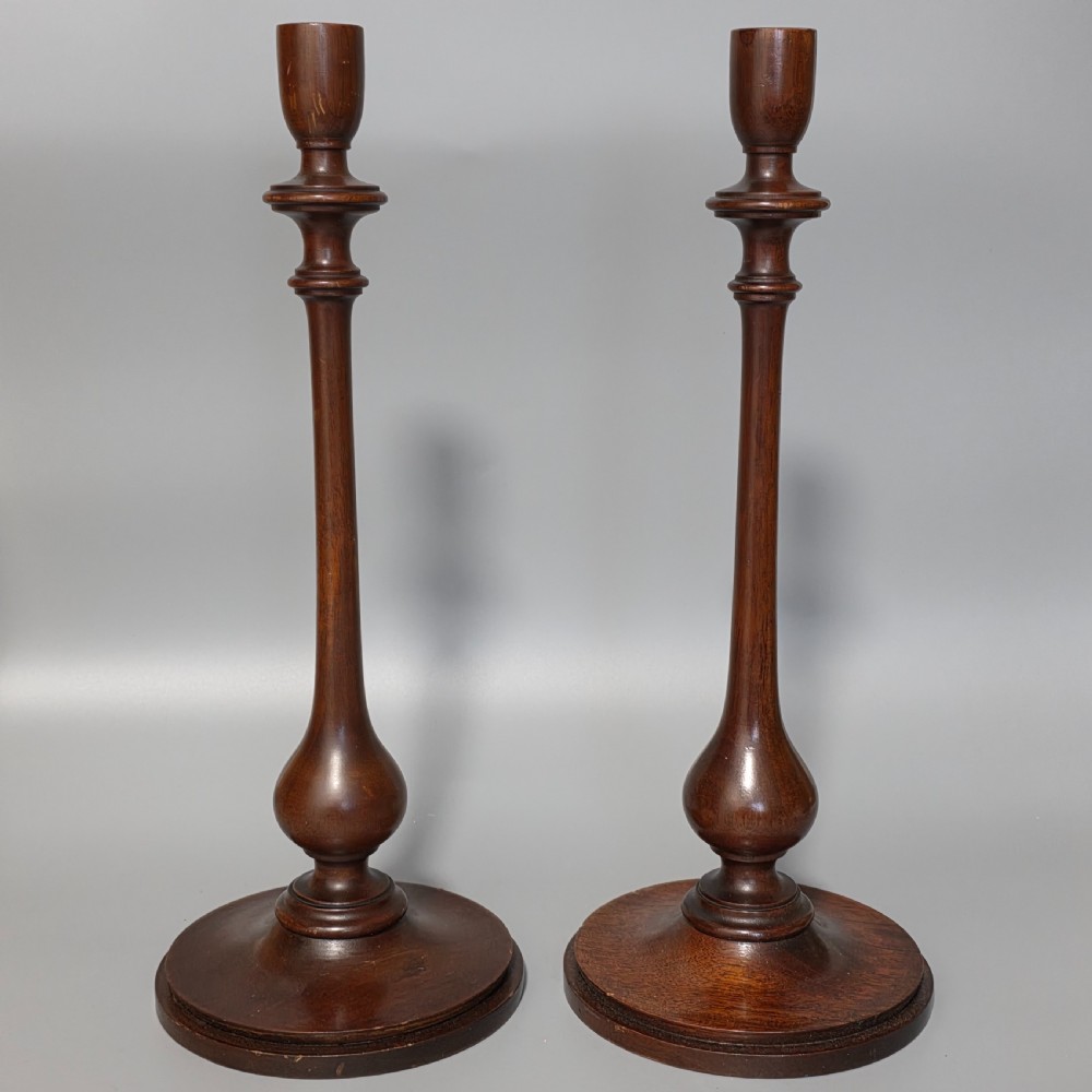 A pair of tall turned dark wood candlesticks featuring bulbous lower shafts and circular stepped bases. View III