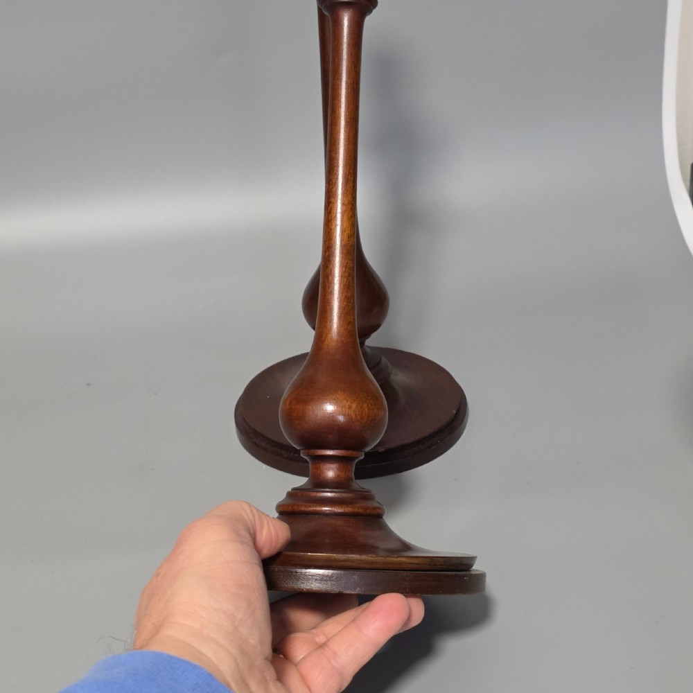 A pair of tall turned dark wood candlesticks featuring bulbous lower shafts and circular stepped bases. View IX