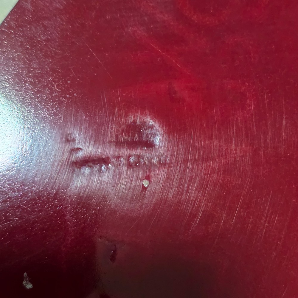 A shallow ceramic art pottery plate featuring a crimson red flambe glaze combined with golden-brown crystalline textures and a scalloped edge. View VI