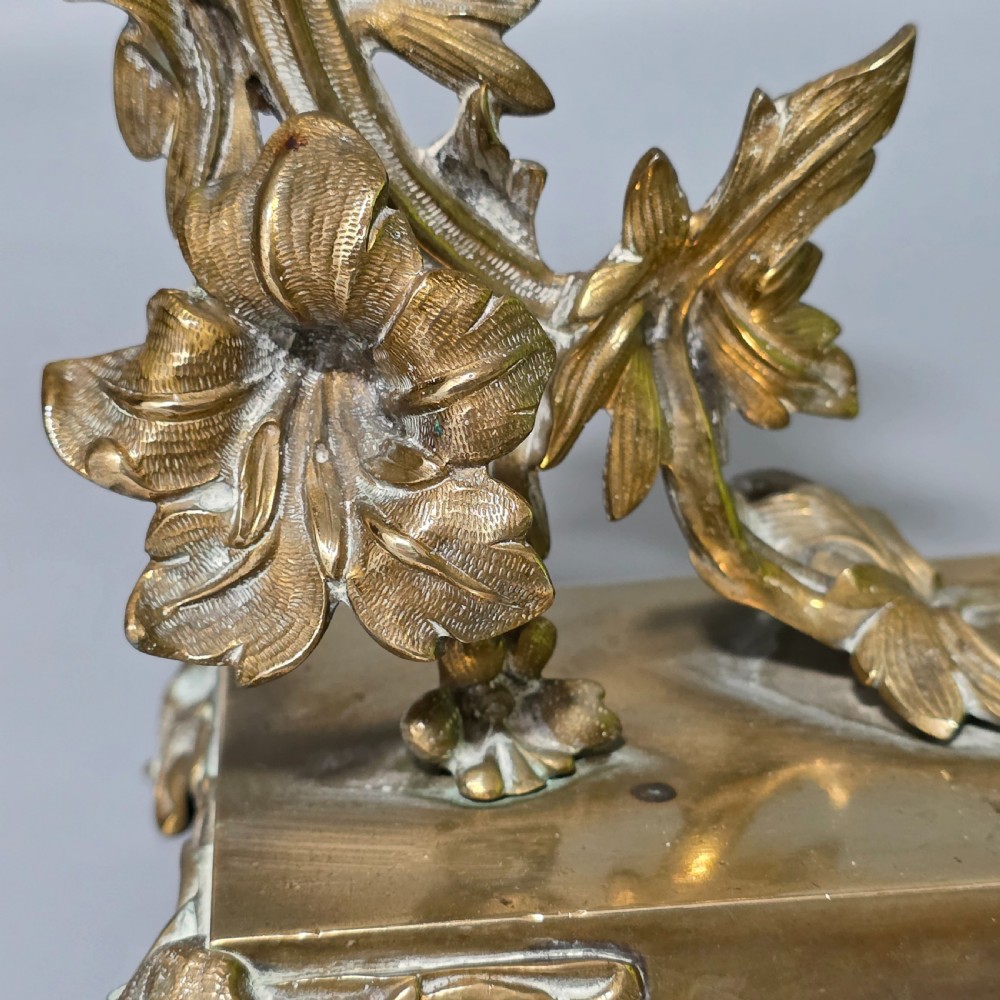 A pair of 19th-century French Napoleon III cast brass candlesticks featuring ornate scrolling leaf motifs and rectangular bases. View V