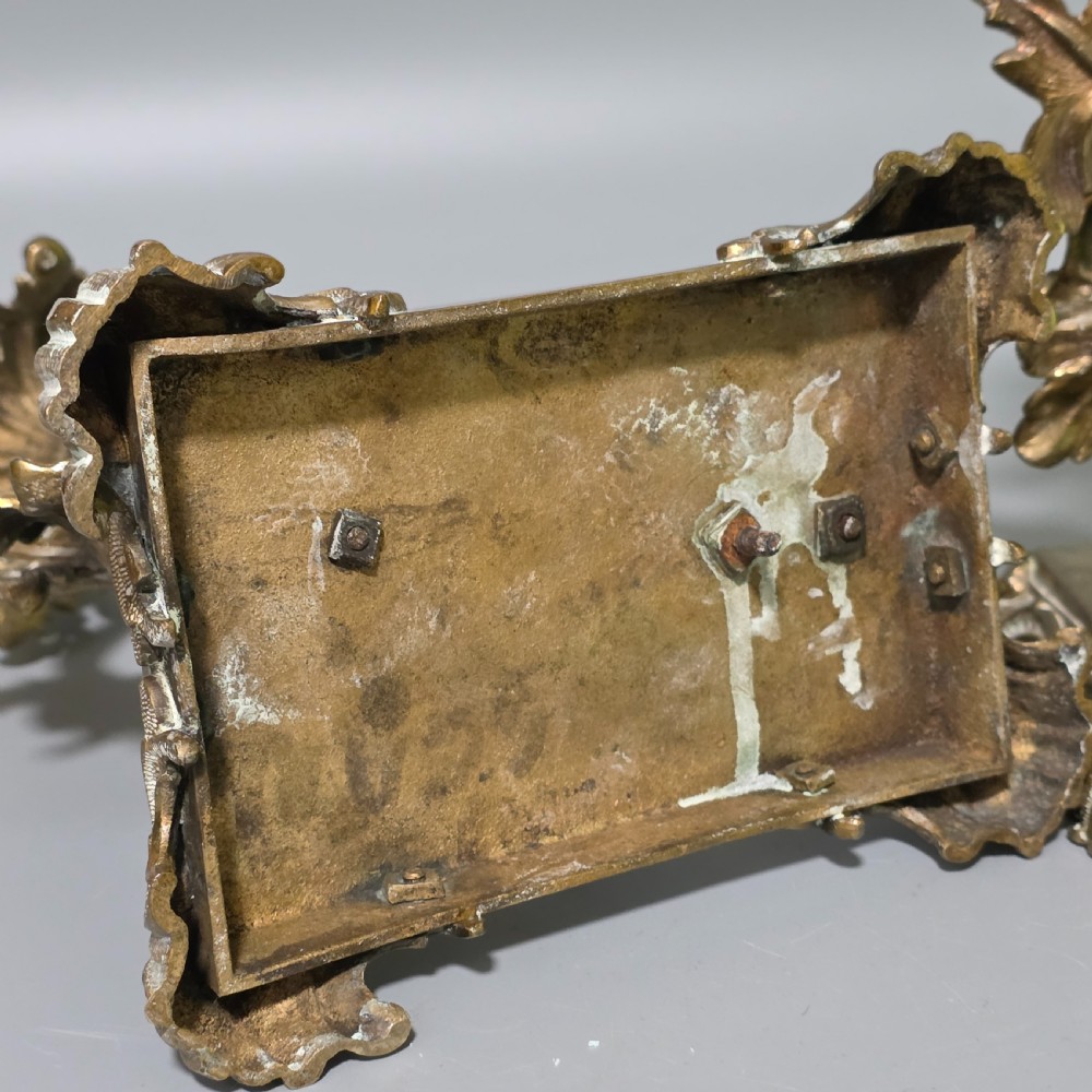 A pair of 19th-century French Napoleon III cast brass candlesticks featuring ornate scrolling leaf motifs and rectangular bases. View VII